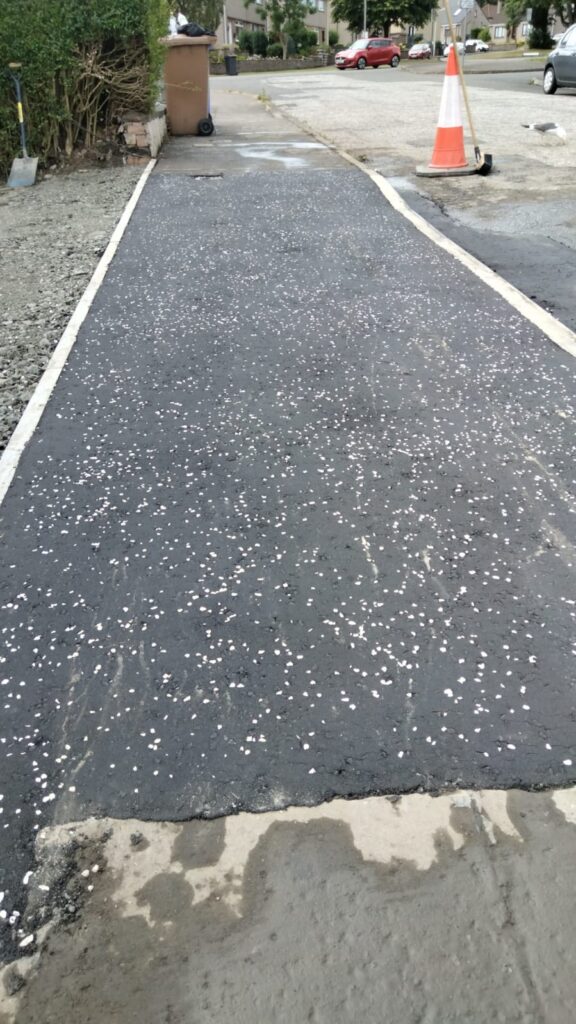 drop kerb with tarmac and white chip stones